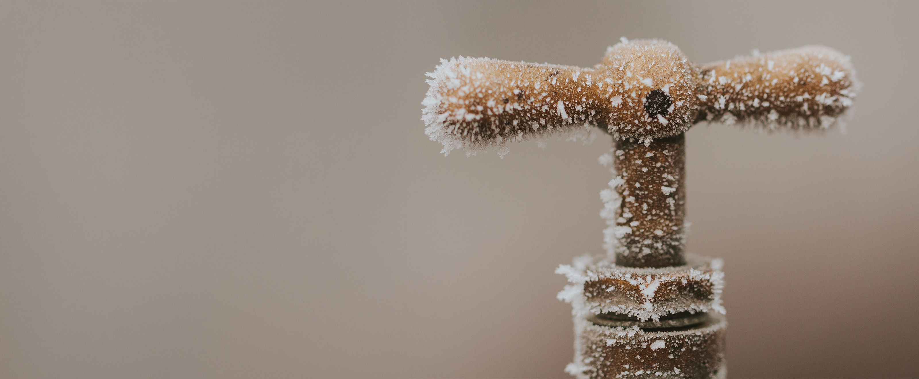 Close up photo of a copper tap handle covered in frost and ice crystals