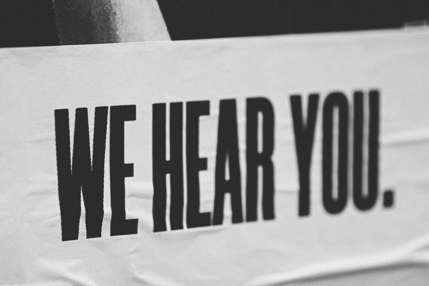 Photo of a banner that reads 'We hear you'