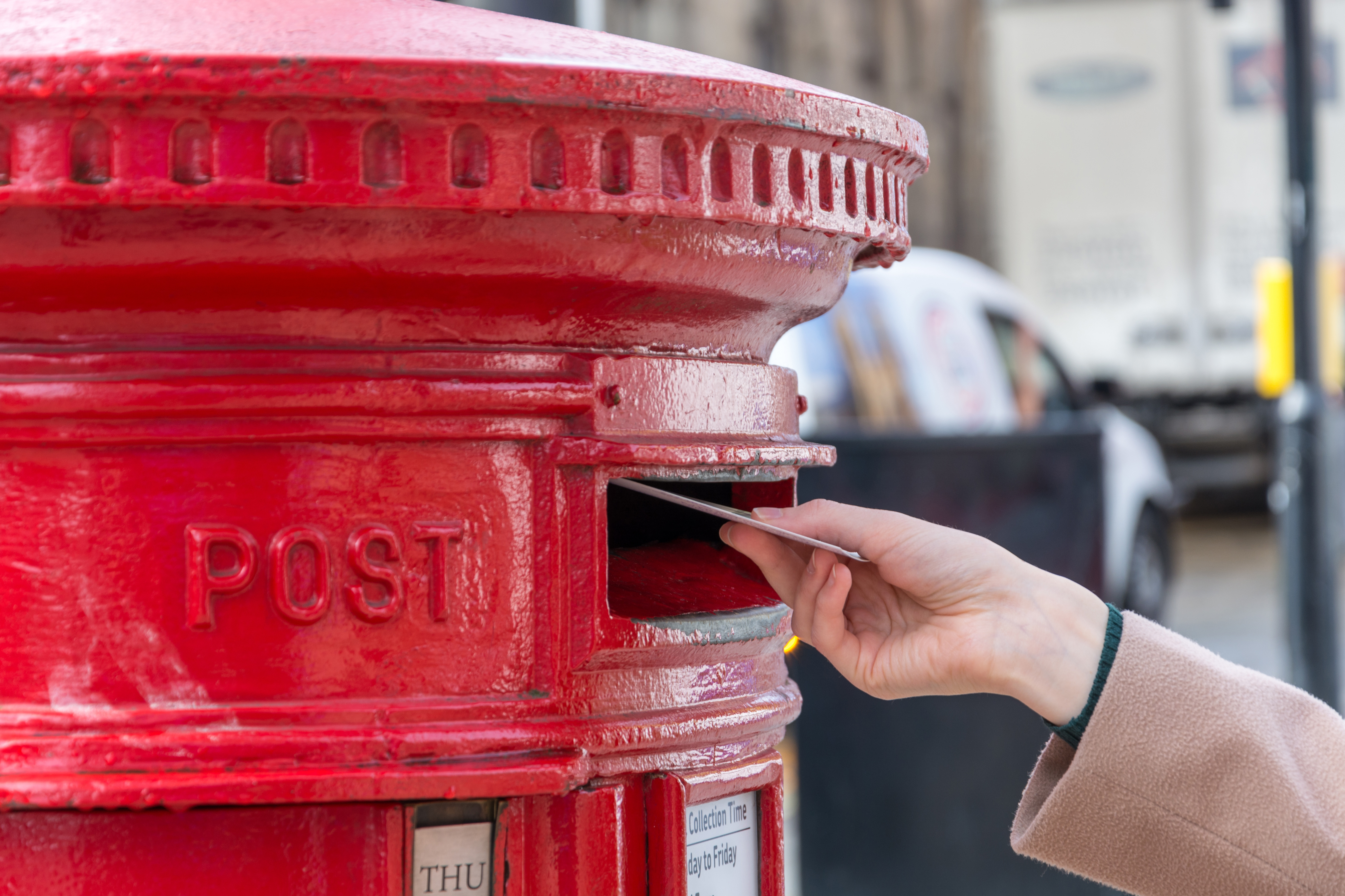close up hand holding red mailbox