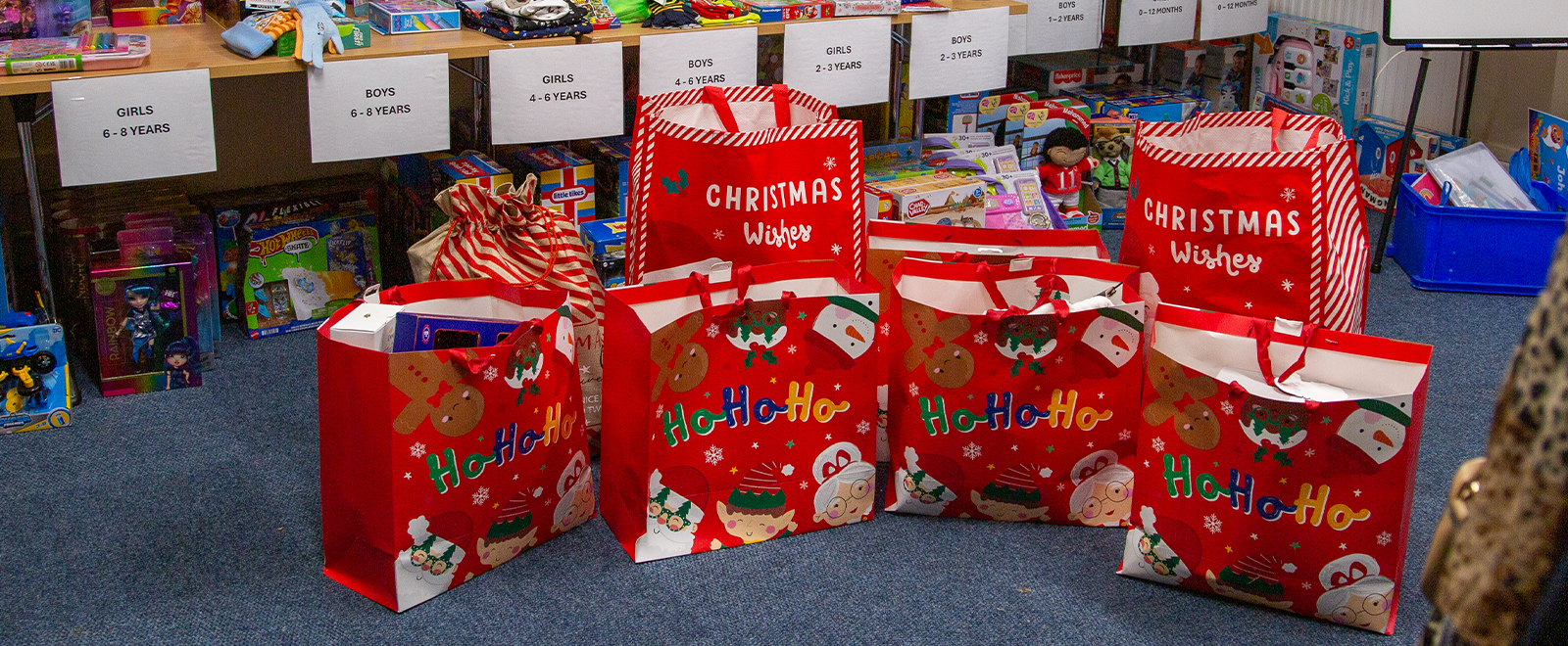 Photo of six Christmas gifts bags in a room with toys