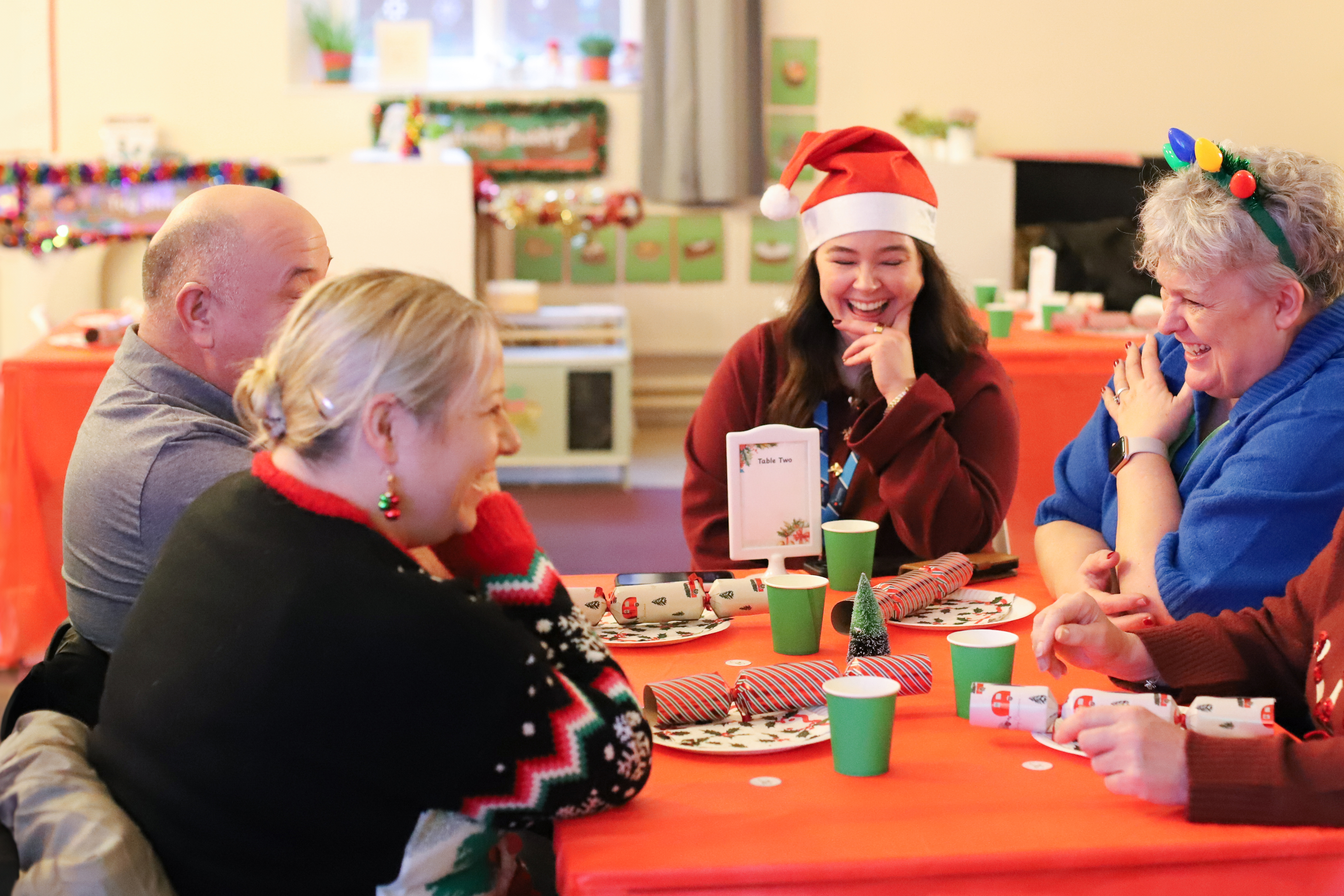 Photo of people sitting around a table with Christmas decorations on