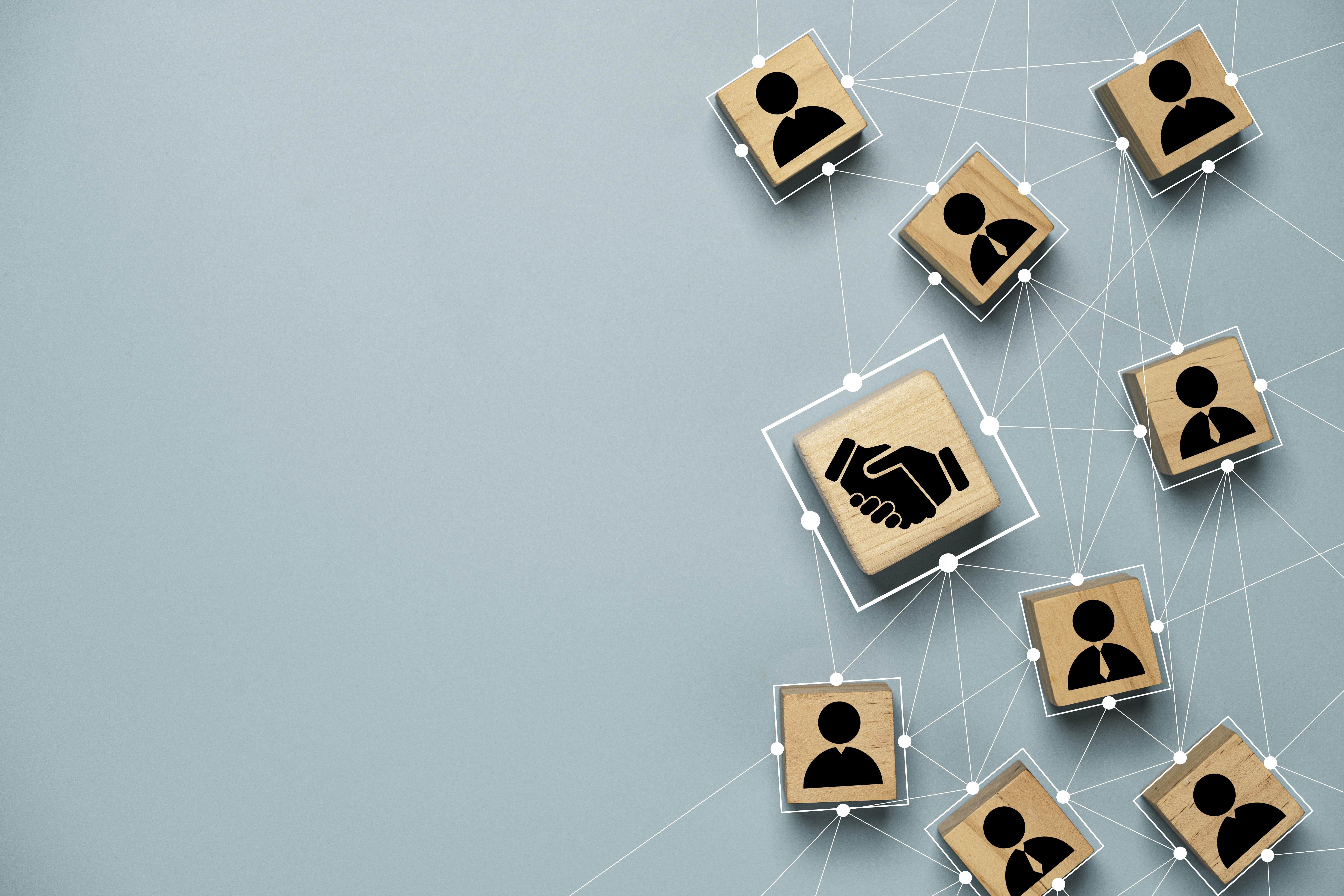 Nine business themed wooden blocks connected by lines on a blue background. 