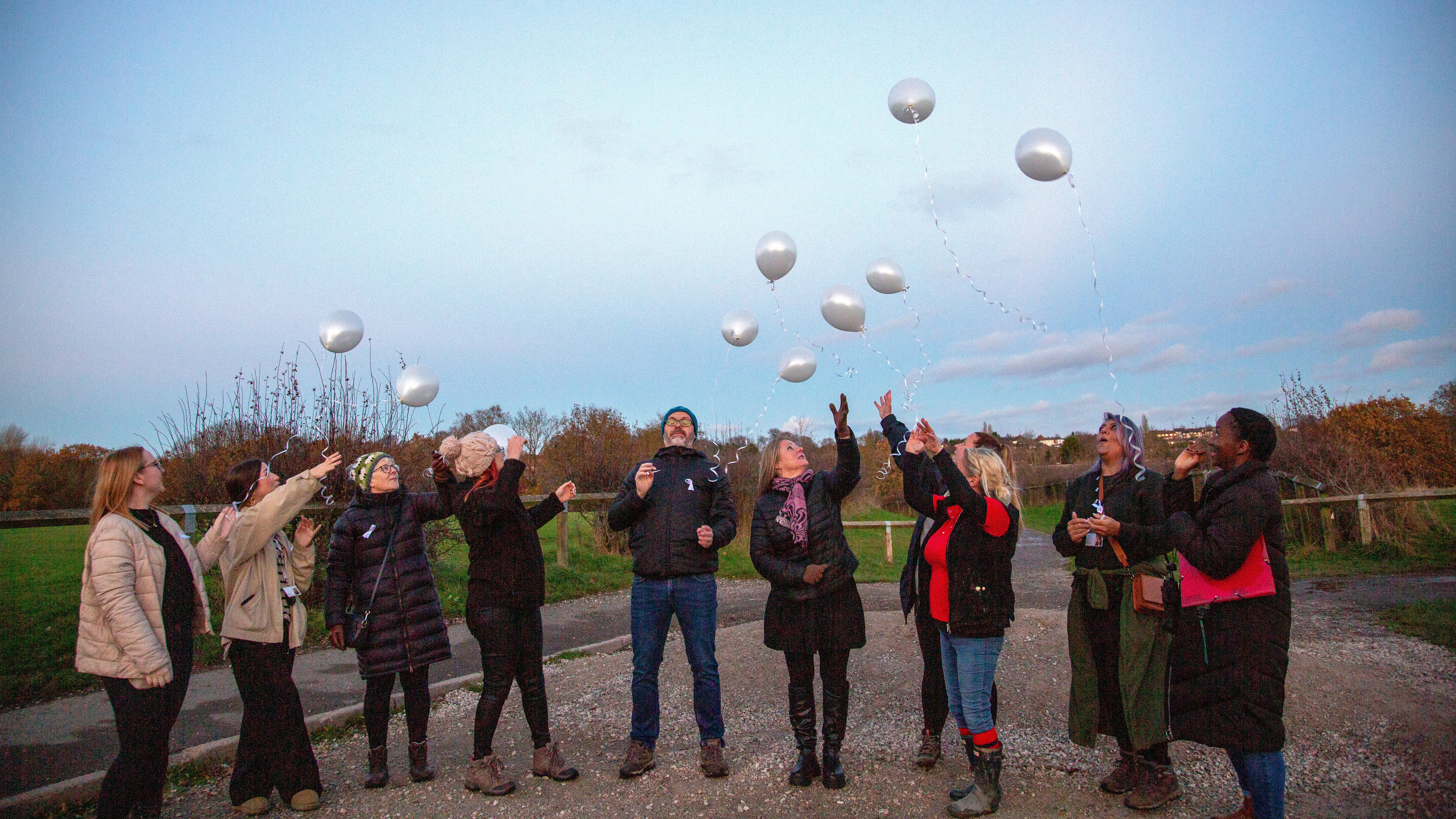 Photo of a group of people letting go of balloons
